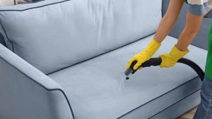 Professional deep cleaning a gray couch